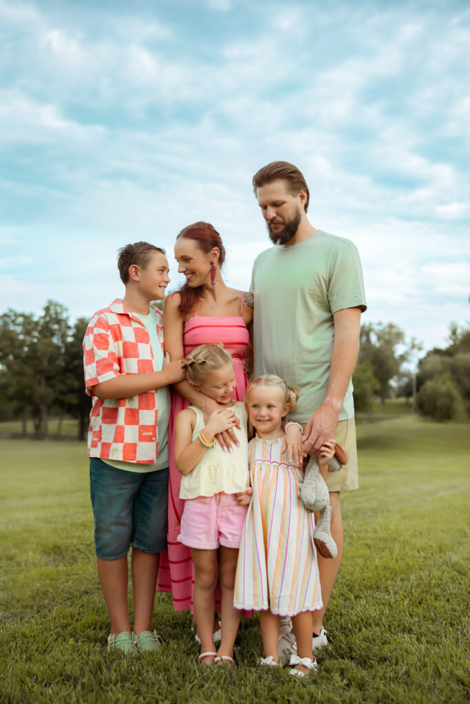 When searching Family Photos Near Me in Kansas City I hope you'll find these beautiful family photos taken in their clients backyard wearing bright colorful summer colors with a blue sky.