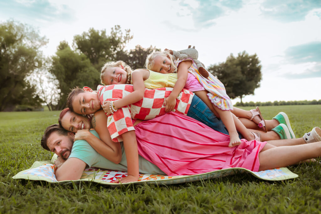 If you search Family Photos Near Me in Kansas City you'll find photographers that love to capture families pile on top of each other in their back yard wearing bright colorful summer outfits all smiling during their family session.